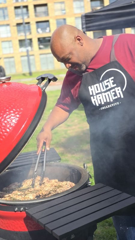 A chef in a Housekamer apron at the kamado