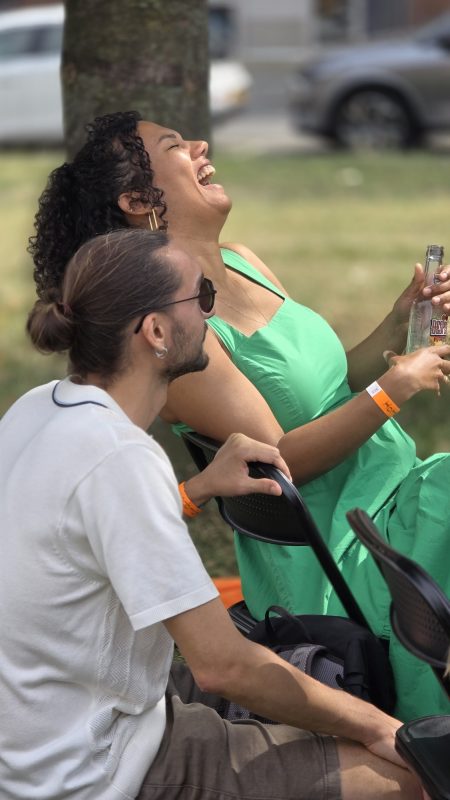 Two guests laughing in the grass