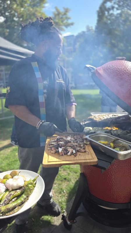 A chef at the grill in the smoke