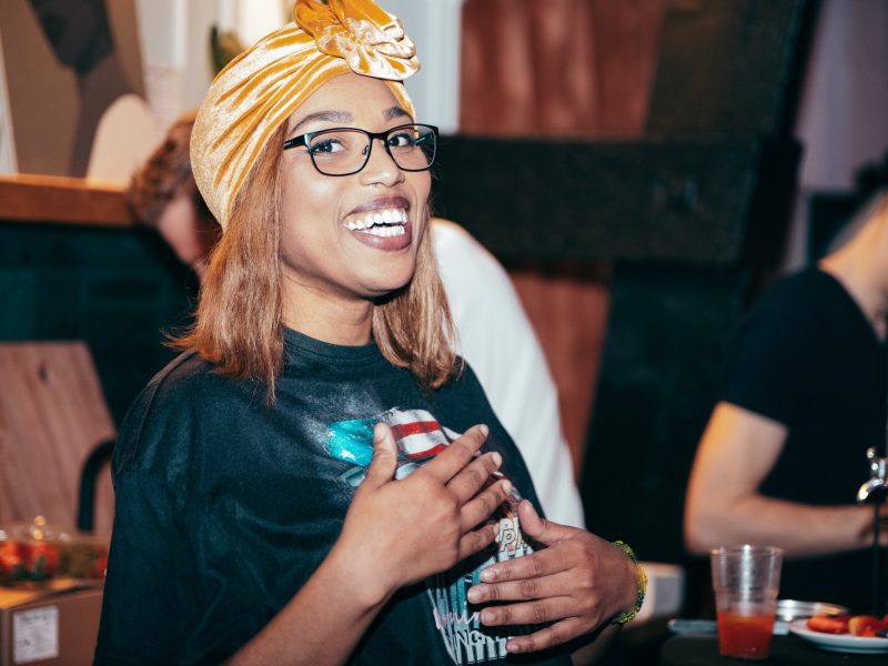 A guest laughing in a golden headwrap
